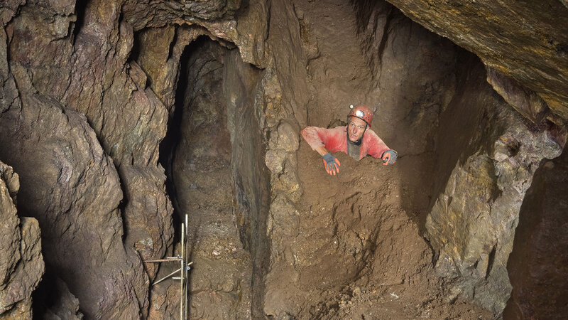 Mann klettert in den Höhlen der Alpirsbacher Stollen